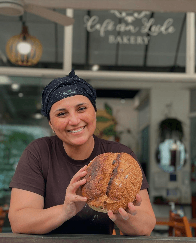 Imagem da Leide segurando um pão italiano artesanal